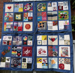 large quilt of multiple colourful quilt squares on dark blue background