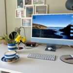 A photo of my desk, with a cup of coffee and yellow flowers