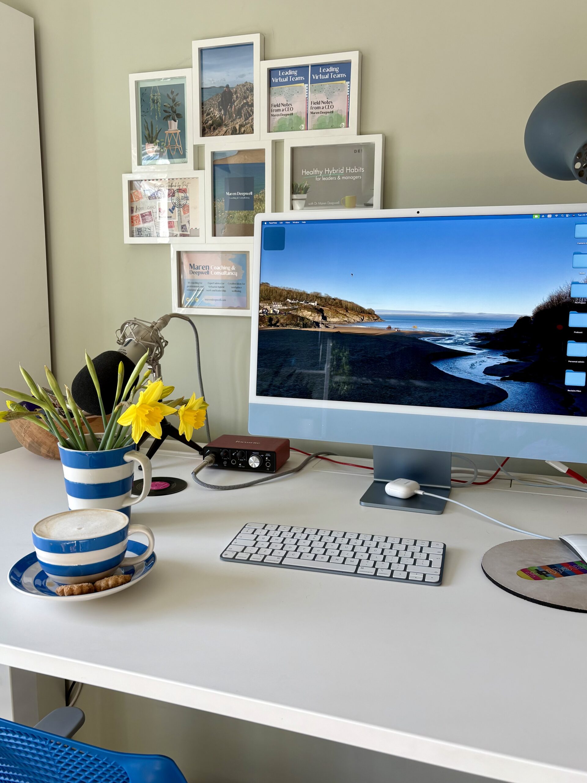 A photo of my desk, with a cup of coffee and yellow flowers